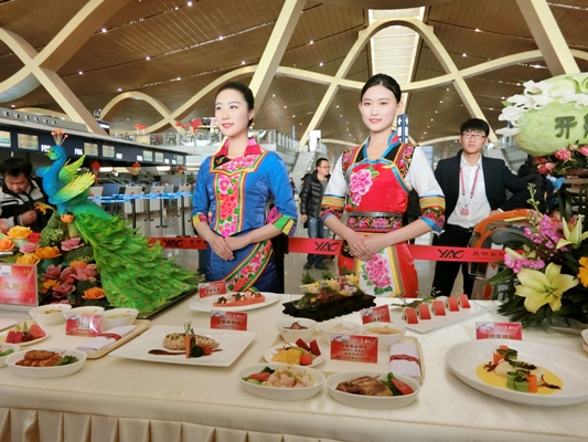 身着民族服装的乘务员现场展示昆航机上特色餐食.JPG