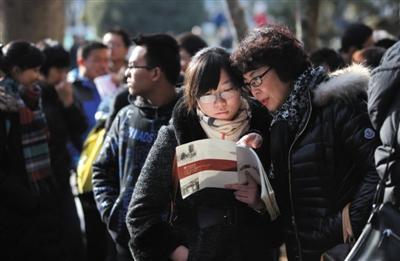 去年12月21日，北大举行自主招生面试和体能测试，考生和家长翻阅北大简介。资料图片/新京报记者薛珺摄